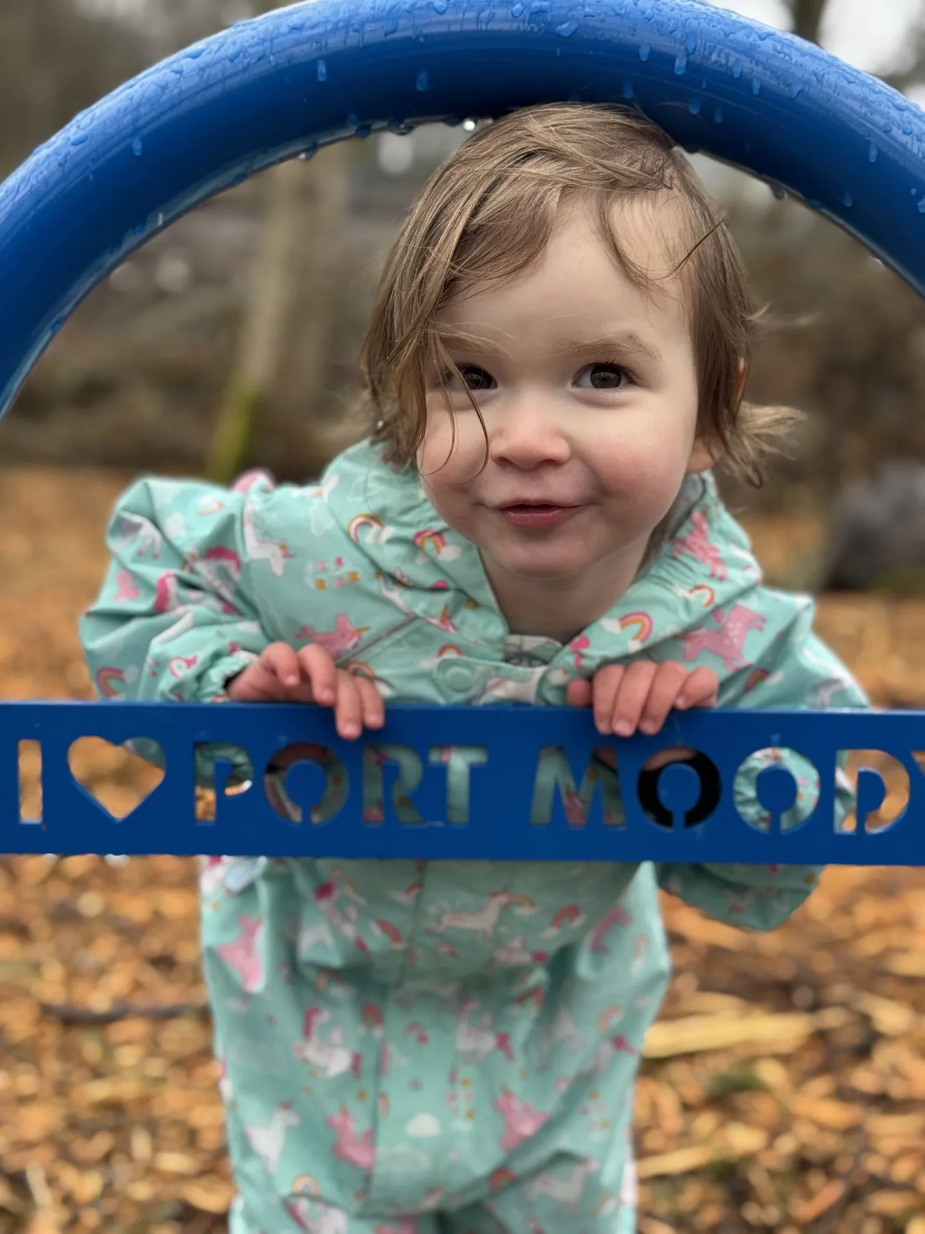 A young supporter on the playground holding an 'I Love Port Moody' sign.